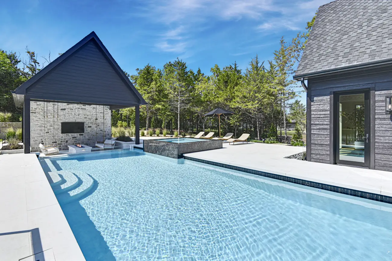 Pool beside a stone pool house with hanging swings