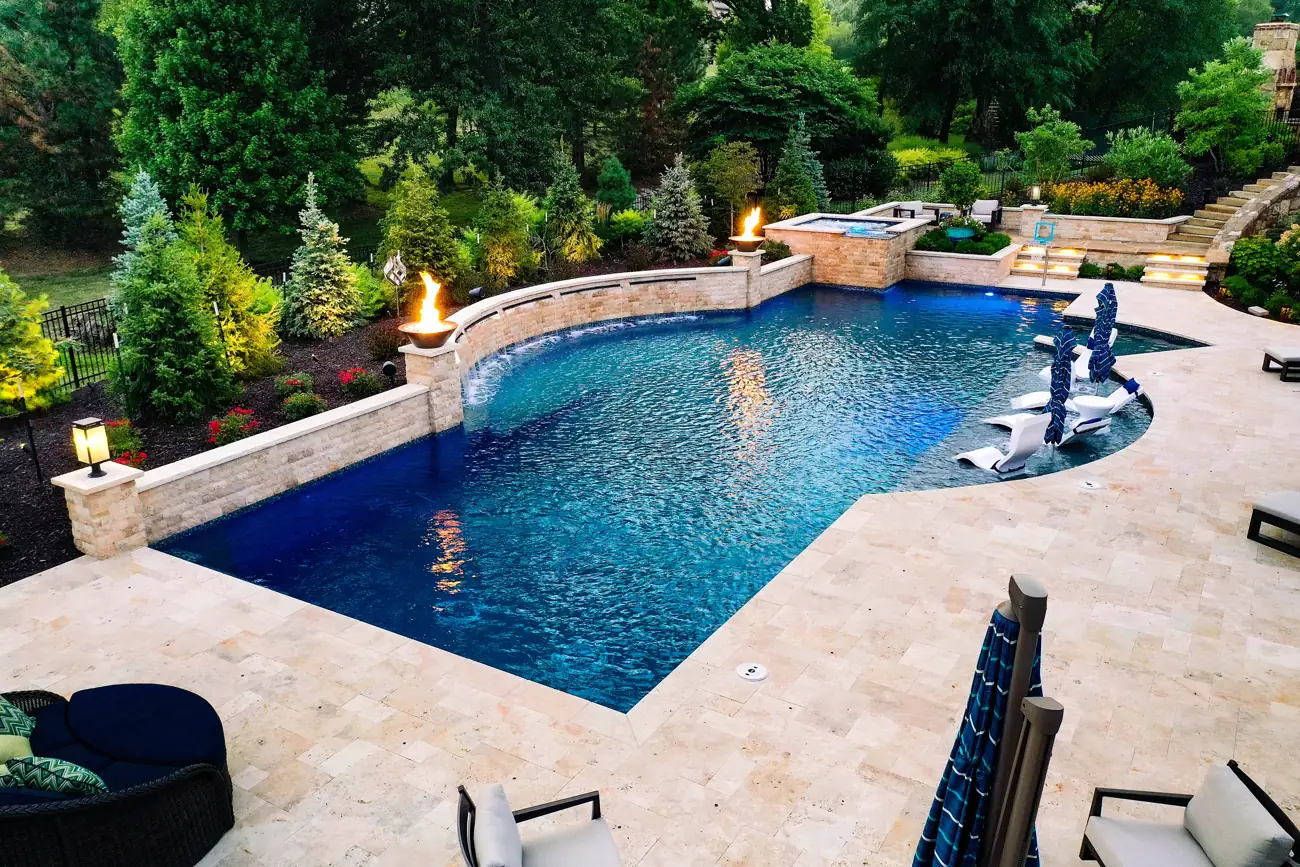 Pool with stone spillover wall and travertine deck